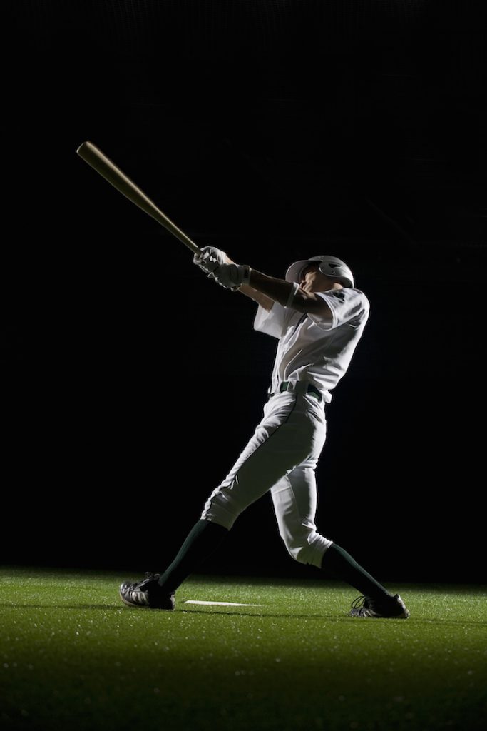 Baseball batter swinging bat, side view